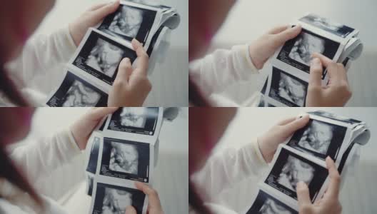 孕妇看3D超声扫描照片。高清在线视频素材下载