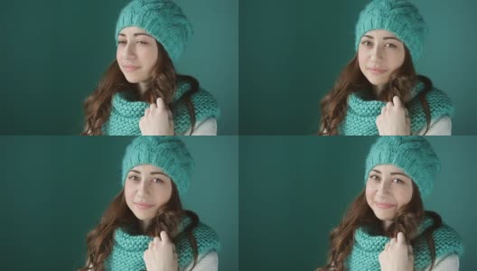 美丽的年轻女子，戴着绿松石编织的帽子和围巾高清在线视频素材下载