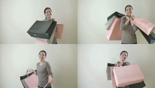 肖像微笑的亚洲美丽的女人提着购物袋在手里高清在线视频素材下载