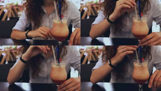 一个女人在咖啡馆喝鸡尾酒的特写镜头用吸管，慢动作高清在线视频素材下载