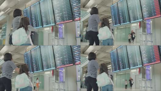 亚洲母亲和她的女儿在机场寻找航班时间高清在线视频素材下载