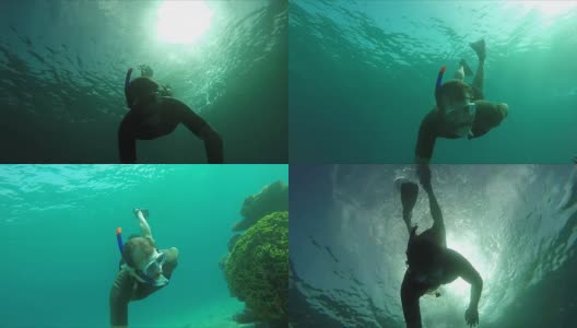 潜水员在阳光下游过珊瑚礁高清在线视频素材下载