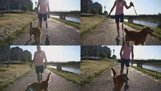 截肢者和他的狗在河边散步高清在线视频素材下载