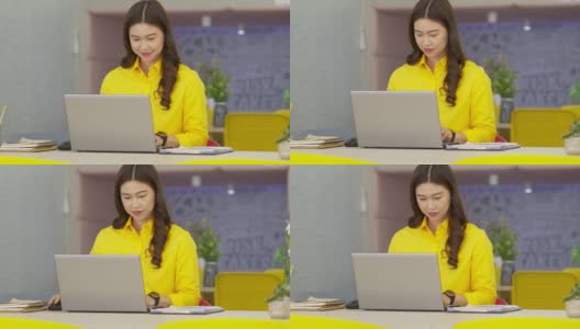 幸福迷人的亚洲女人在现代办公室或联合办公空间的商业创业的想法和要求，黄色衬衫与电脑笔记本电脑工作，创业概念高清在线视频素材下载