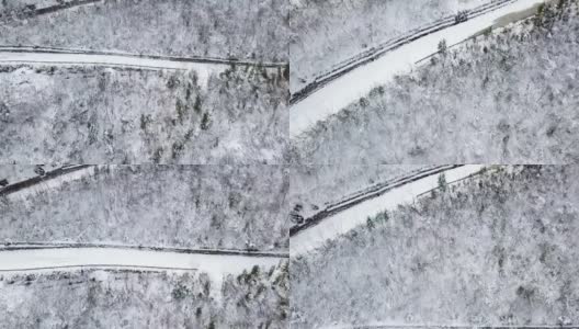 鸟瞰图弯曲的山路上山穿过松树和其他树木覆盖在冬天的雪。山在四川西岭。高清在线视频素材下载