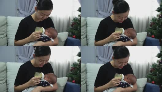 母亲在客厅里给婴儿喂奶高清在线视频素材下载