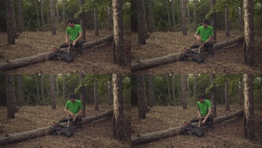 一个徒步旅行者在森林里用干木头建了一个避难所高清在线视频素材下载