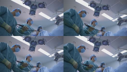 外科医生的医疗灯背景。医生团队合作，在医院进行手术和使用现代医疗设备。视图从下面。高清在线视频素材下载