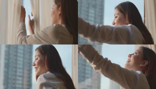 迷人的亚裔女性。早晨拉开窗帘，望着窗外，微笑着生活方式，自然的美，感觉像在家里一样高清在线视频素材下载