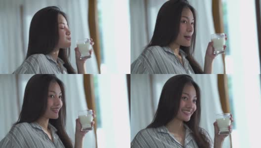 面部表情由年轻女子在清纯清晨时分，喝牛奶，好兆头高清在线视频素材下载