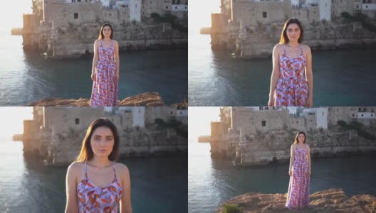 慢动作的漂亮女人站在波利尼亚诺一个Mare城市，意大利高清在线视频素材下载