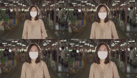 亚洲妇女戴着白布口罩，在新冠肺炎疫情中微笑高清在线视频素材下载