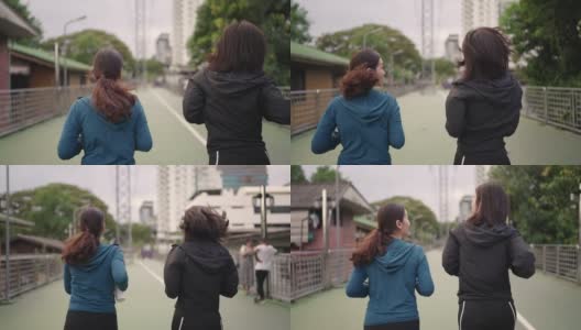 两个亚洲女运动员一起跑在公园，后视镜，慢镜头高清在线视频素材下载