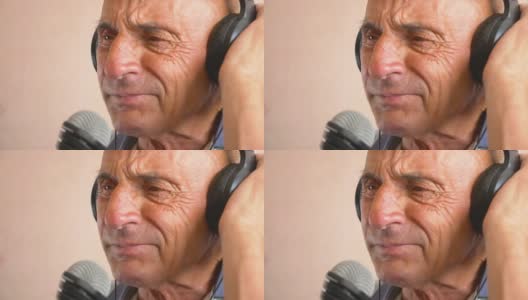 老年人在家的悠闲。一位白种老人戴着耳机，用麦克风深情地唱着歌。老年人唱卡拉ok的肖像。快乐的老人在唱歌。高清在线视频素材下载