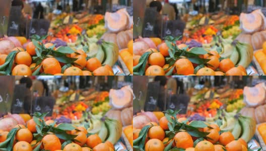 前景是有着绿叶和奇异果实的橘子。蔬菜市场。种类繁多的蔬菜和水果可供选择。健康的新鲜有机素食食品在柜台上。高清在线视频素材下载