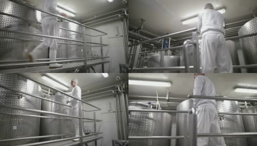食品厂的工人打开巴氏杀菌罐。乳制品高清在线视频素材下载
