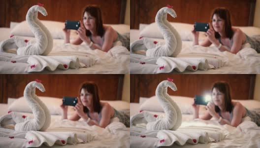 女孩用手机拍了一张用毛巾做的天鹅的照片高清在线视频素材下载