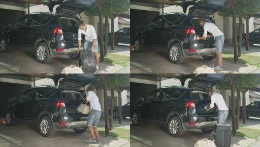 慢镜头:一个穿着白衬衫的年轻人正在把他的行李装进一辆黑色的大车里。高清在线视频素材下载