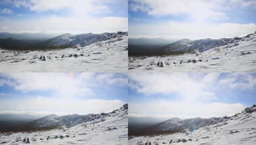 冬季的山脉景色，云和阴影笼罩着雪景。视频。雪山和阳光灿烂。山坡和山脊上覆盖着新鲜的粉状雪高清在线视频素材下载