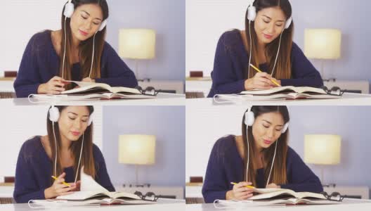 一个中国女人一边听音乐一边做作业高清在线视频素材下载