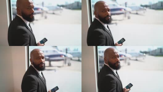 一名商人在窗前使用智能手机的肖像高清在线视频素材下载