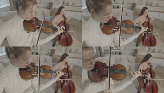 弦乐二重奏的妇女演奏小提琴和大提琴在豪华的家庭室内高清在线视频素材下载