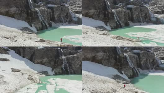 阿尔卑斯山景观的超断层。在山峰之间的绿松石湖边慢跑的女人。高清在线视频素材下载
