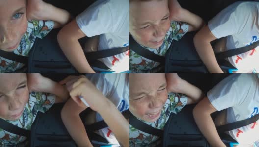 一个厚脸皮的男孩在车里被捅了一下，然后假装哭了一声表示同情，然后关掉他的表情，看着镜头。高清在线视频素材下载