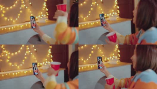 亚洲妇女使用智能手机视频聊天与她的朋友在家里高清在线视频素材下载