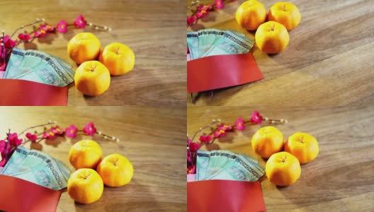 橘子和带有马来西亚货币的木制背景的中国红包高清在线视频素材下载