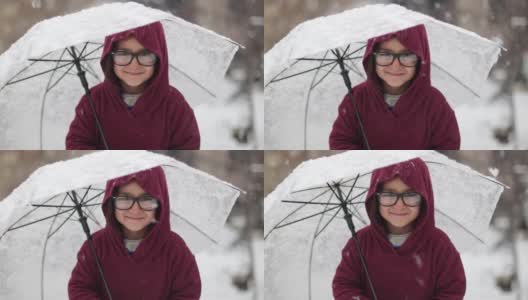 小女孩在雪下打着伞高清在线视频素材下载