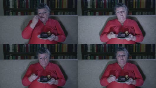 胖老女人一边看电视一边吃蛋糕高清在线视频素材下载