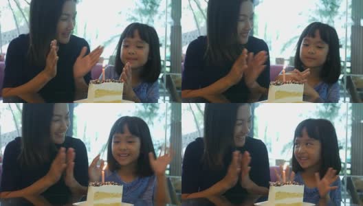 女孩和妈妈一起在咖啡店享用生日蛋糕高清在线视频素材下载