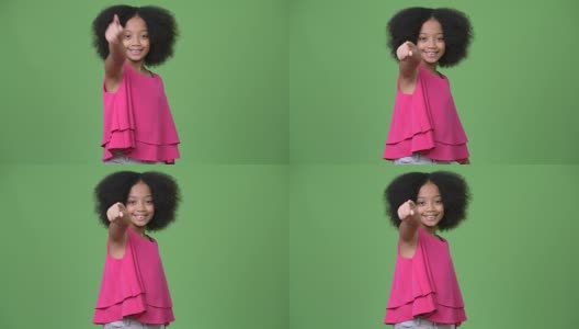 年轻可爱的非洲女孩与非洲式的头发指着手指高清在线视频素材下载