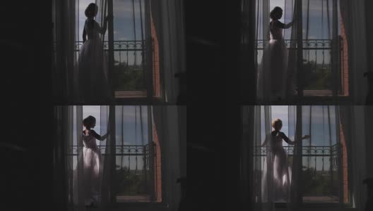 一个年轻女子走近窗户，打开阳台，欣赏。清晨新娘等待婚礼高清在线视频素材下载
