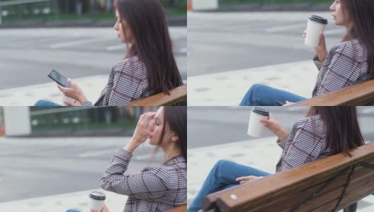 穿着便服坐在木凳上的女人。女孩拿着香浓的咖啡高清在线视频素材下载