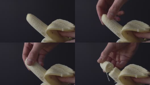 在一个黑暗的特写背景上，一个男人的手掰下了一根成熟的香蕉高清在线视频素材下载