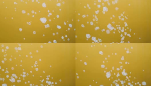 白色的肥皂泡在黄色背景的慢动作中飘动高清在线视频素材下载