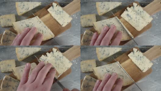 男性用手在砧板上切布里干酪。高清在线视频素材下载