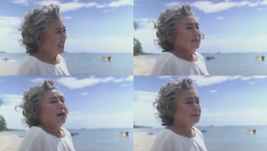 资深女士在海滩上深呼吸，微笑高清在线视频素材下载