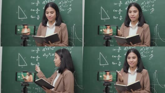 年轻的亚洲女教师站在摄像机和学生视频会议。女教师在课堂上通过智能手机在线课程直播培训数学。高清在线视频素材下载