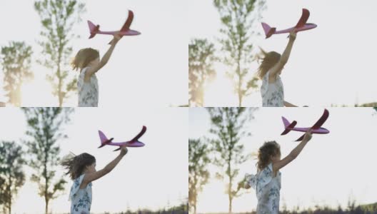 女孩带着玩具飞机在夕阳下的田野上奔跑。孩子们玩玩具飞机。青少年梦想飞行，成为一名飞行员。女孩想成为一名飞行员和宇航员高清在线视频素材下载