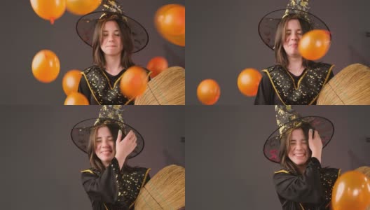 一个小女孩手里拿着扫帚，有人朝她扔橙色的气球，她在笑。高清在线视频素材下载