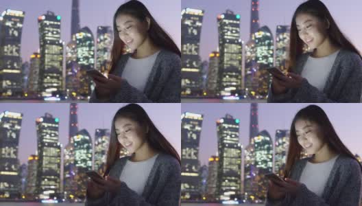年轻的亚洲妇女在现代城市玩手机高清在线视频素材下载