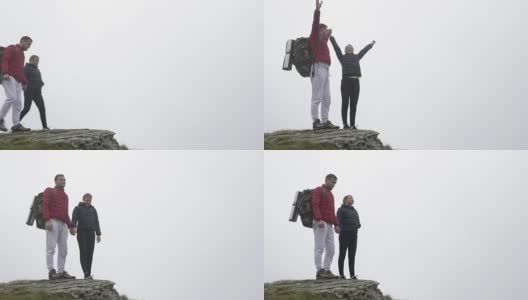 运动情侣在到达山顶时举手欢呼，亲吻，欣赏风景高清在线视频素材下载
