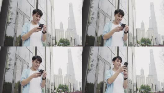 年轻的亚洲男子使用手机与现代办公大楼高清在线视频素材下载