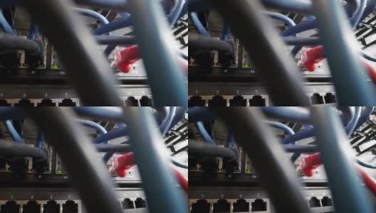 混乱的Cat5e以太网电缆插入闪烁的网络交换机与混乱的高速英特千兆位Cat5数据补丁线缆在IT组网柜的背景高清在线视频素材下载