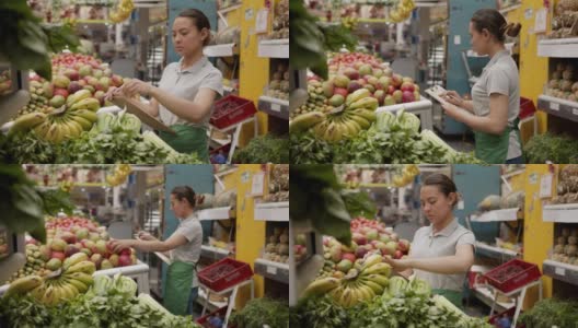 拉丁美洲的女售货员正在她的市场摊位上用写字板清点蔬菜高清在线视频素材下载