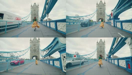 一个漂亮的女孩穿着裙子在伦敦塔桥上奔跑，英国。高清在线视频素材下载