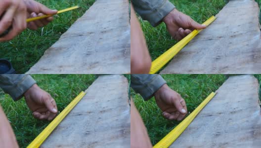 男性建筑工用卷尺或尺测量木板的尺寸高清在线视频素材下载